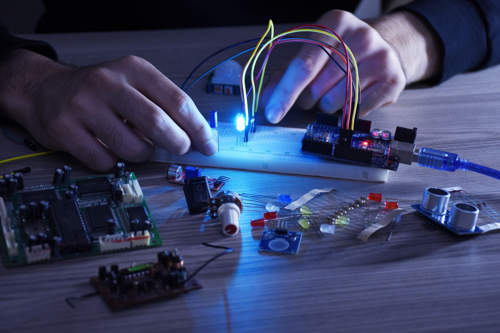 An engineer working on arduino project, breadboard, electronic module